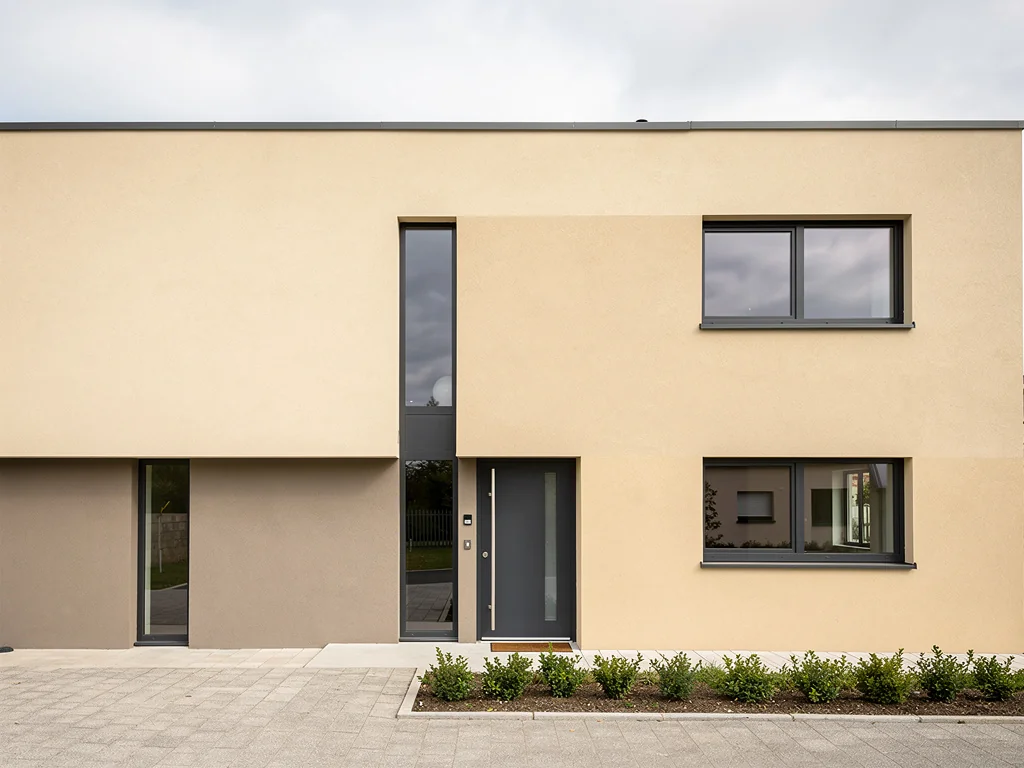 Façade de maison enduite en teinte sable après isolation des murs par l'extérieur